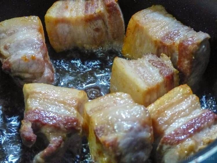 大きな角切りにした豚バラ肉を多めの油で焼く様子