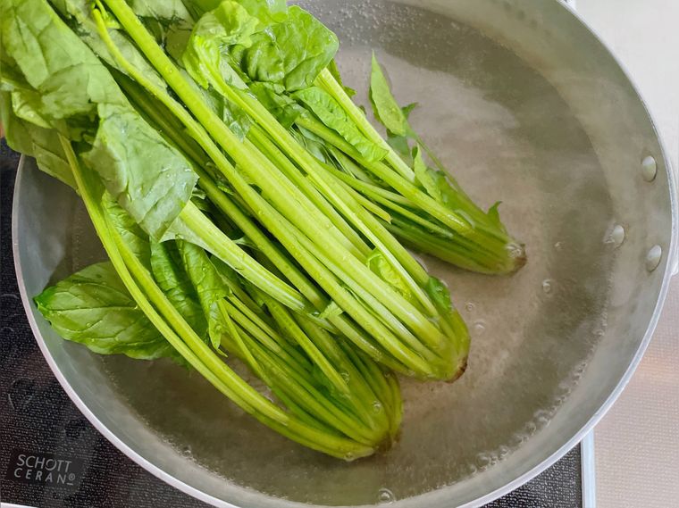 ほうれん草の根元を鍋に入れる様子