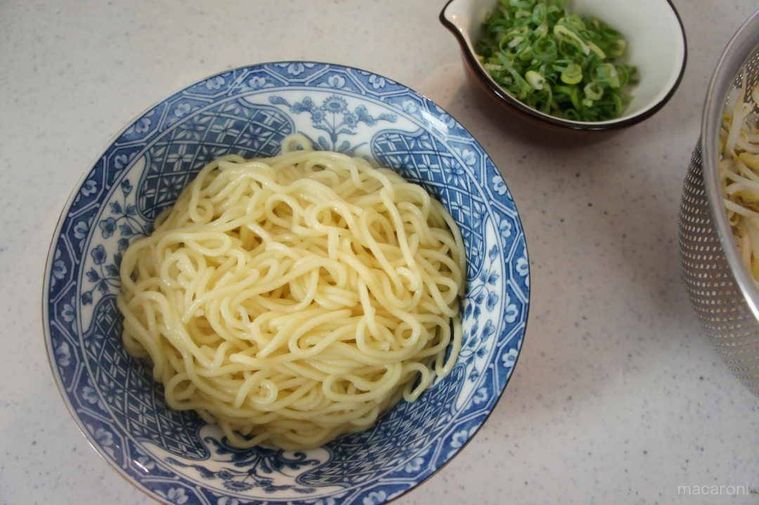 湯がいた中華麺を水切りして器に入れています。