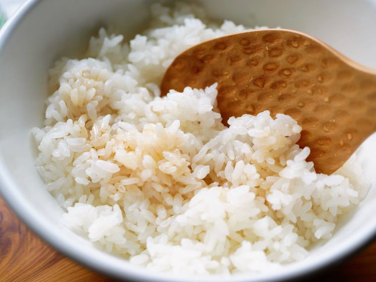 白いボウルに入った白米に茶色い麺つゆがかかっており、木のしゃもじが添えられている様子