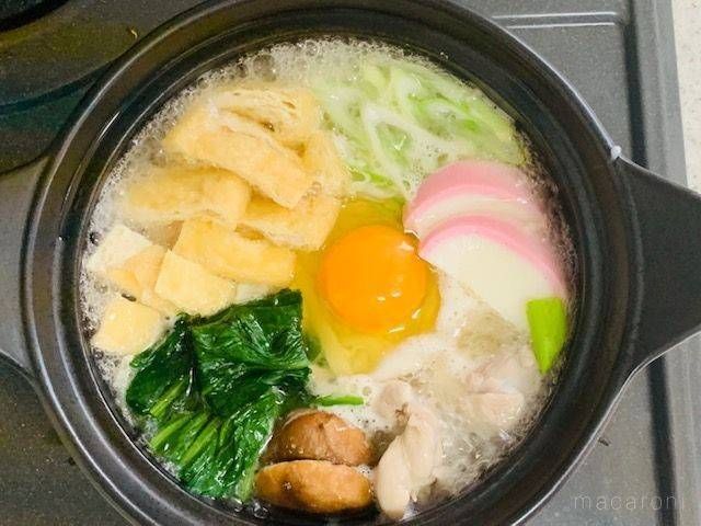 鶏肉や卵、しいたけ、ほうれん草などの具材を煮込んでいる鍋焼きうどん