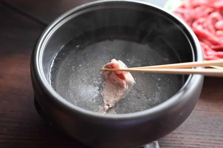 鍋の中で牛肉を熱湯にくぐらせている様子