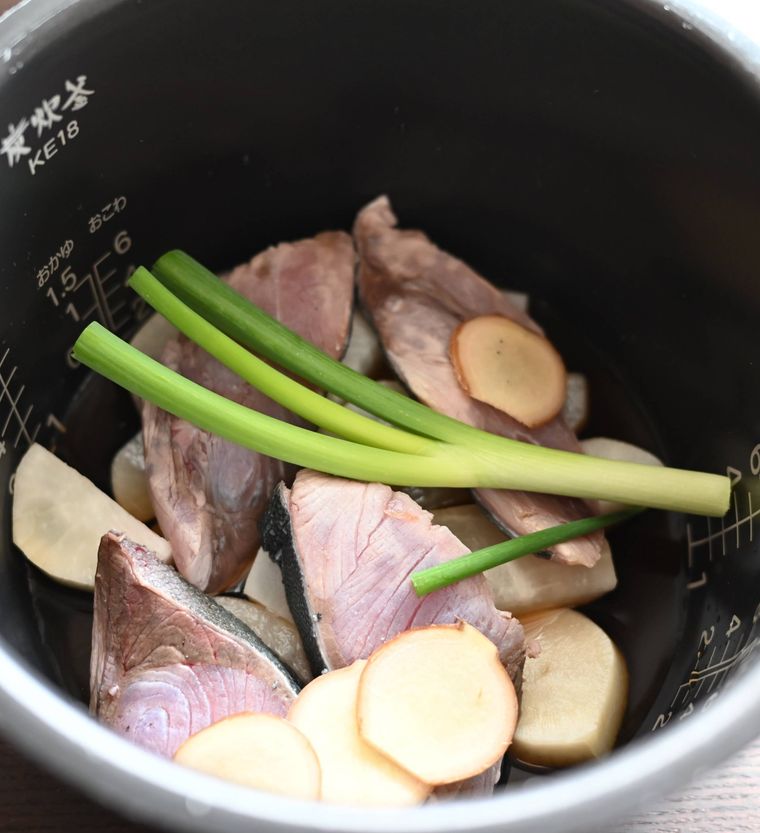 炊飯器の釜の中に入ったぶり大根の材料