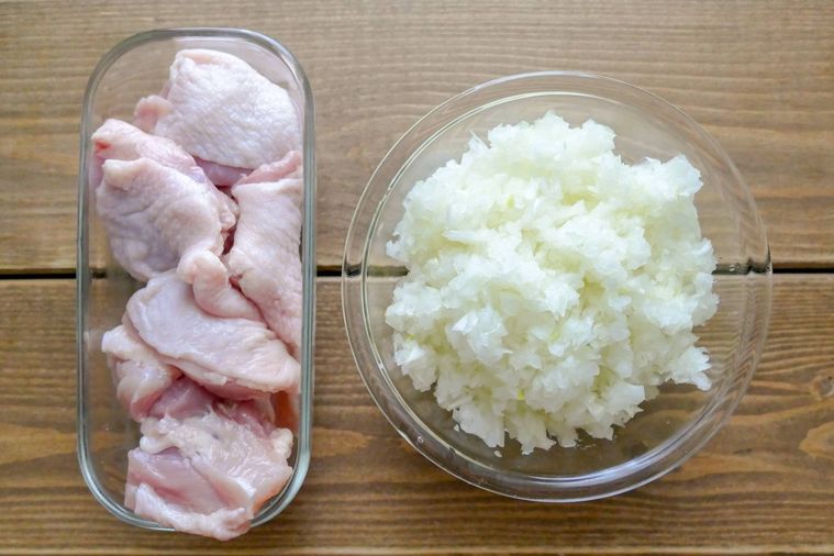 カット済みの鶏もも肉とみじん切り玉ねぎが並ぶテーブル