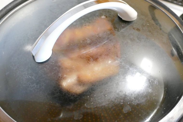 豚肩ロース肉が入っているフライパンに蓋をして蒸し焼きにする様子