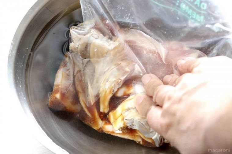 豚肉と調味料が入った密閉袋を水が入ったボウルに入れる様子 photo by: anrichiko
