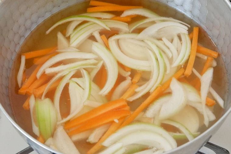 鍋で玉ねぎとにんじんを煮ている様子