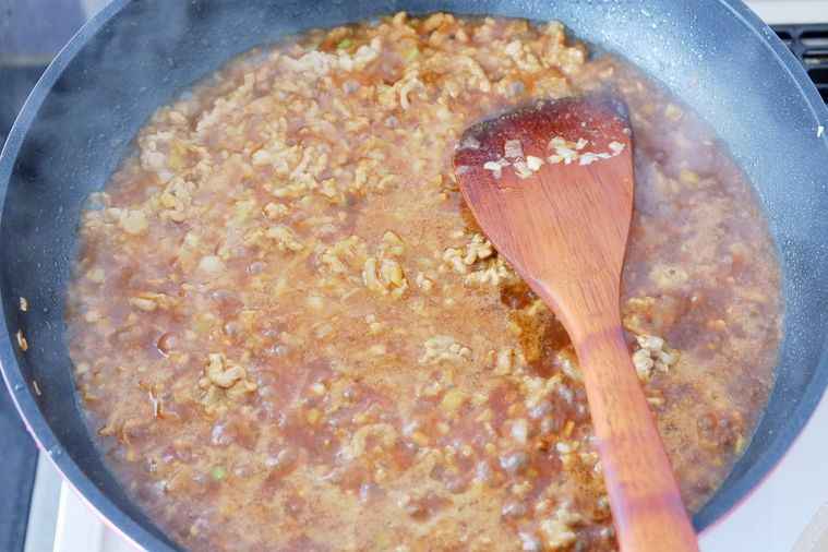 フライパンでひき肉と調味料を煮ている様子