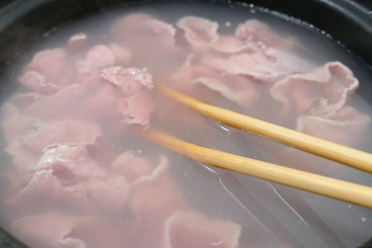 牛肉を菜箸でほぐしながらゆでる様子