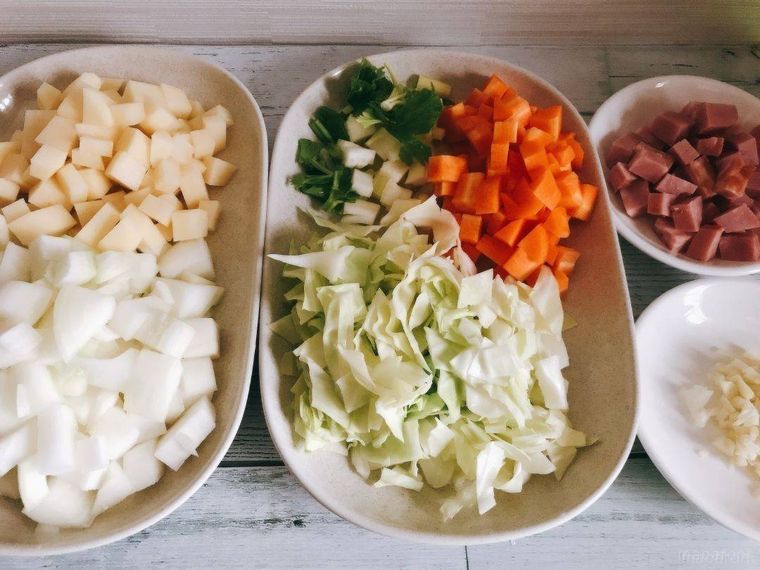 切って皿に置かれている野菜とベーコン