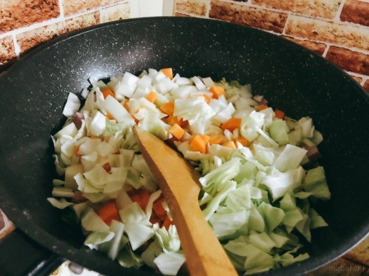 ベーコンと野菜を炒めているフライパン