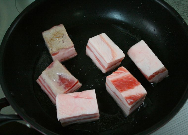 フライパンで豚バラ肉を焼いている様子