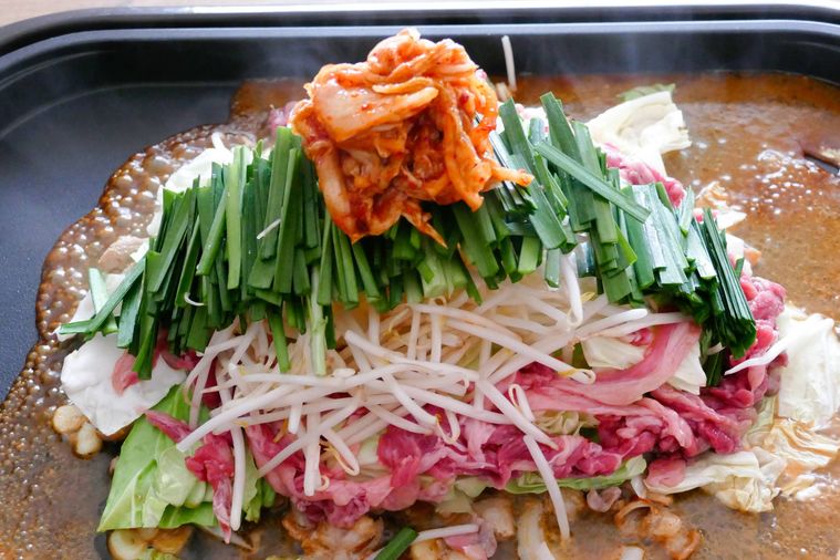 ホットプレートに野菜、牛こま肉、白菜キムチを重ねた様子