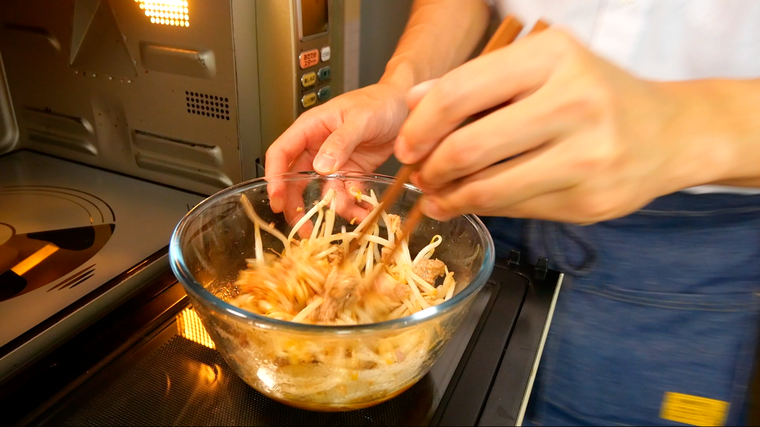 もやしとひき肉を混ぜている様子