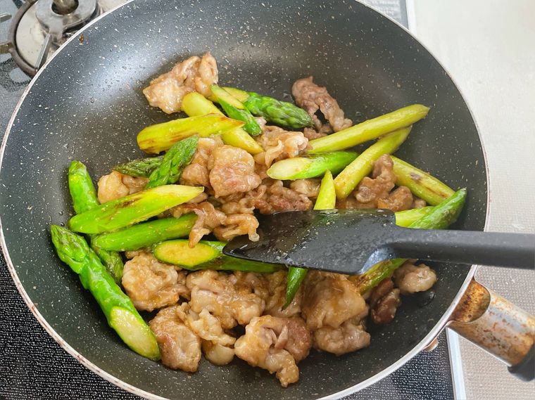 豚こま肉とアスパラを炒める様子