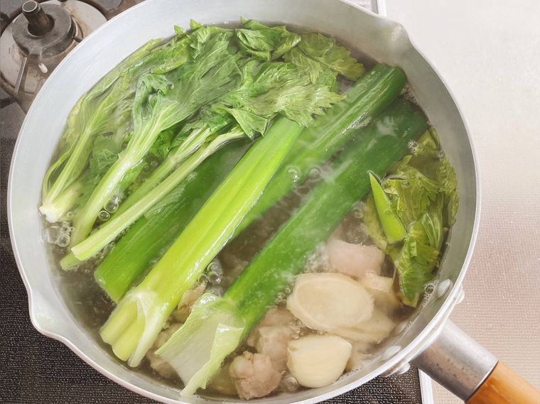 鍋に牛すじ肉、長ねぎ、セロリ、にんにく、しょうがを入れて煮る様子