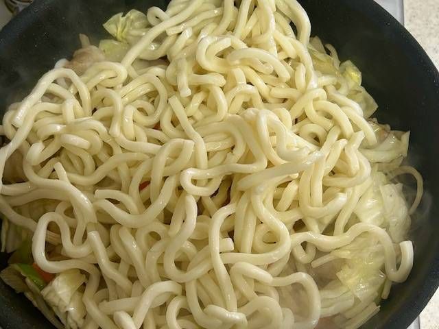 ゆでうどんを加えたフライパン