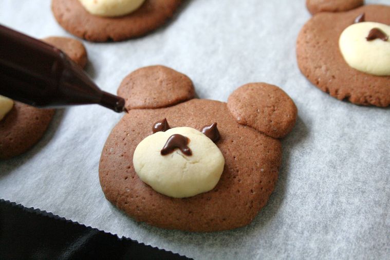 くまクッキーにチョコペンで顔を書いている様子