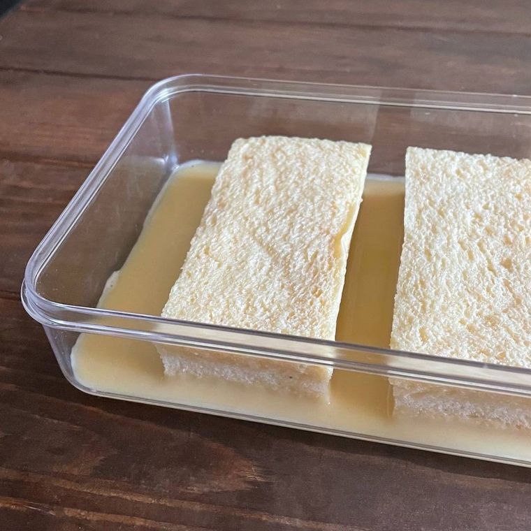 透明な四角い容器に張った卵液につけ込んだ食パン