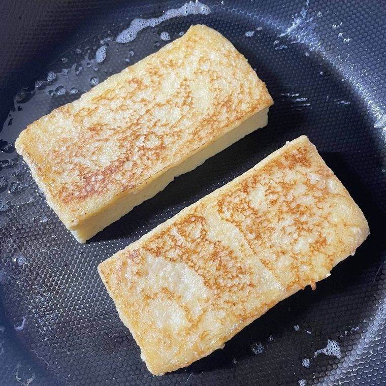 フライパンで焼いているきつね色のフレンチトースト