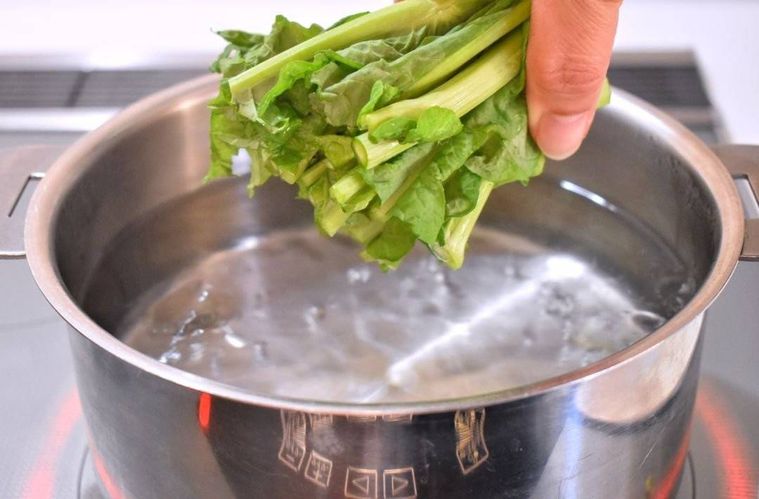 沸騰したお湯に菜の花の茎部分を入れるところ