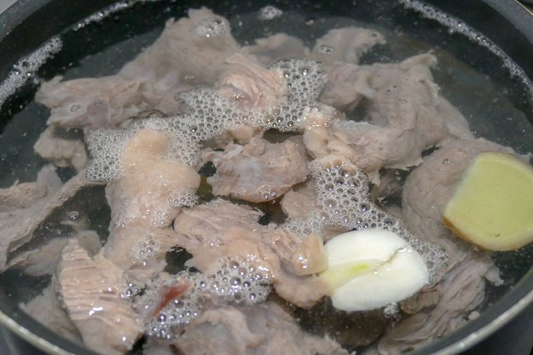 牛すじ肉を鍋でゆでる様子