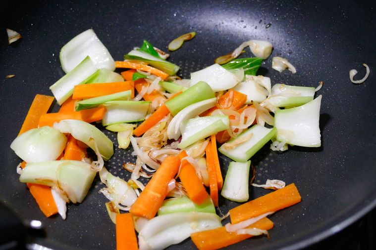 フライパンで野菜を炒める様子