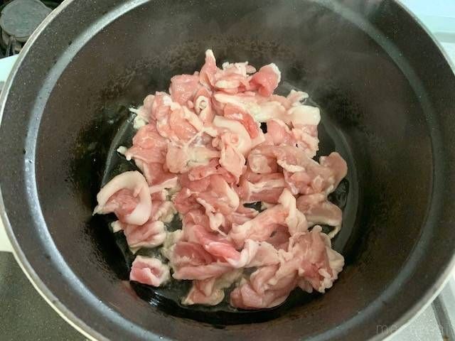 ごま油で炒めている豚肉が入った鍋