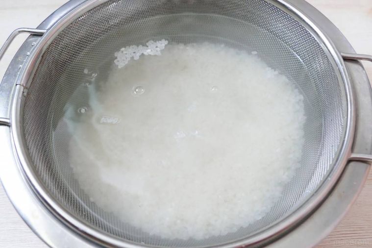 ザルに入れたお米を水に浸す様子