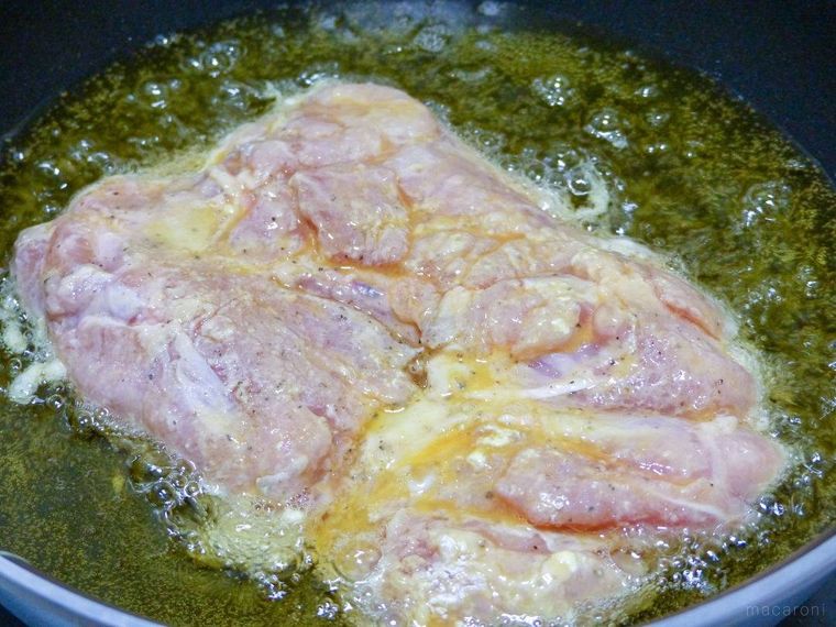 フライパンに注いだ少なめの揚げ油げ鶏肉を揚げる様子