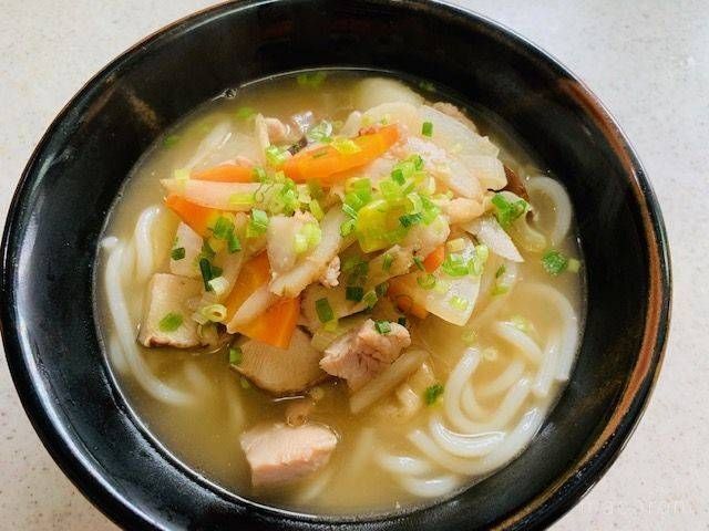 鶏肉と大根、ニンジンなどの具材がのったけんちんうどんの黒いどんぶり