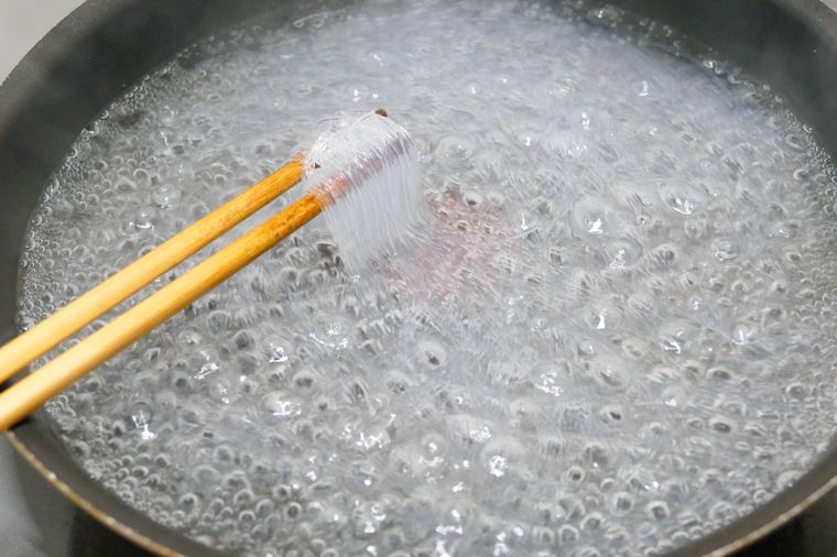 ゆでている春雨を菜箸で持ち上げる様子