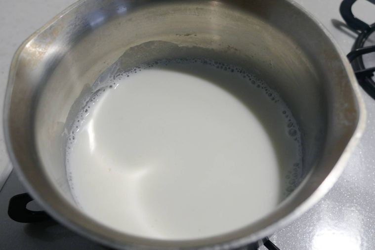 牛乳を小鍋に入れて火にかける様子