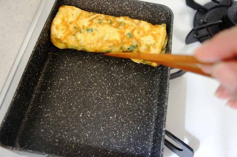 卵焼き器の端に折りたたんだニラ入り卵焼き