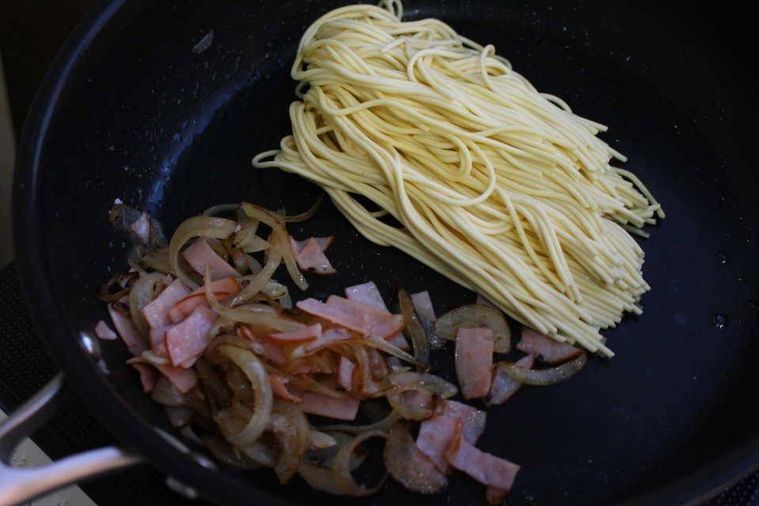 ライパンで玉ねぎ、ハム、水漬けパスタを炒めているところ