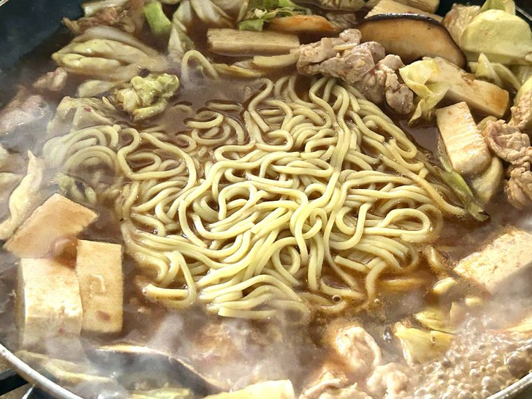 フライパンに中華麺を入れ加熱しているところ