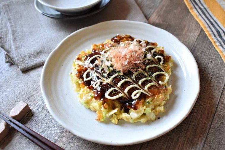 テーブルの上に、山芋入りお好み焼きが盛られたお皿、お箸、取り皿などが並んでいる