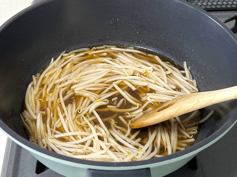 もやし炒めに調味料を加えた様子