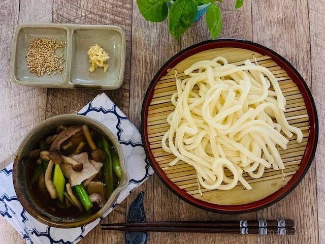 肉汁の入ったお椀とざるに上げたうどん