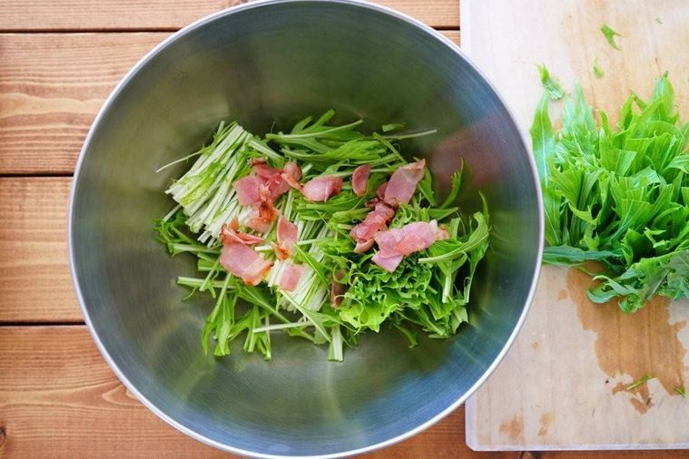 大きめのステンレルボウルの中に水菜の茎とベーコン