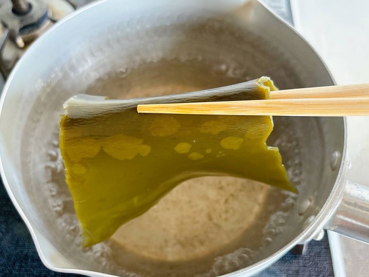 鍋から昆布を取り出す様子