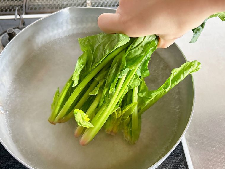 鍋でほうれん草の根元をゆでる様子