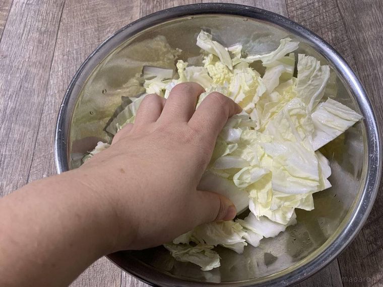 ボウルに入った白菜を手で揉み込むようす