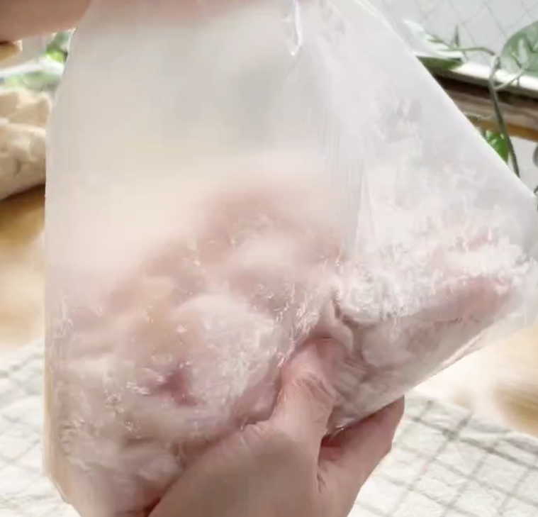 鶏肉の入ったポリ袋を振っている様子