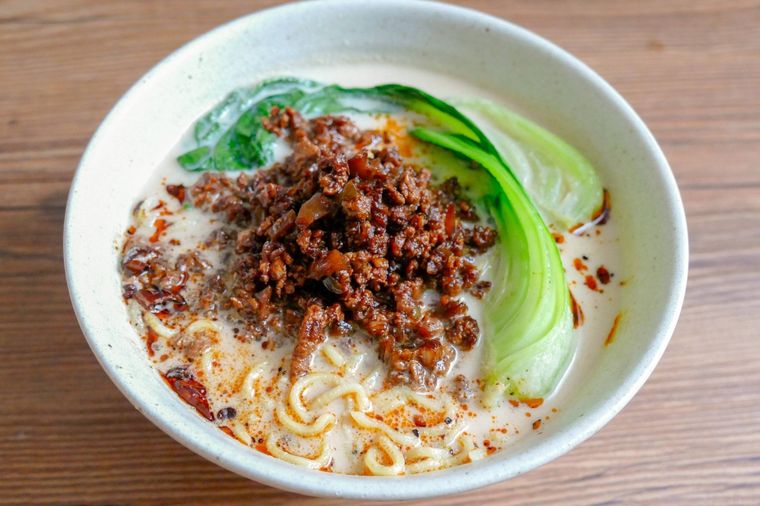 麺とスープ、肉味噌、チンゲン菜を盛り付けた白い丼