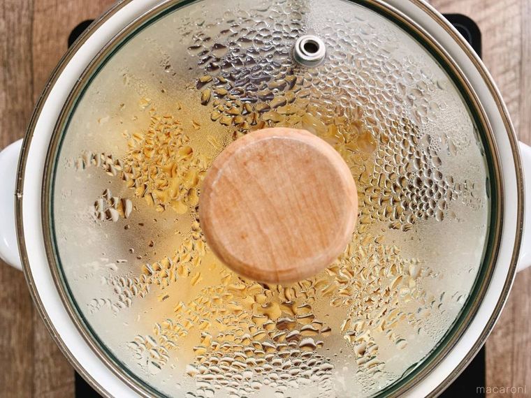 巾着卵の入った白い小鍋に、蓋をして蒸らしている様子