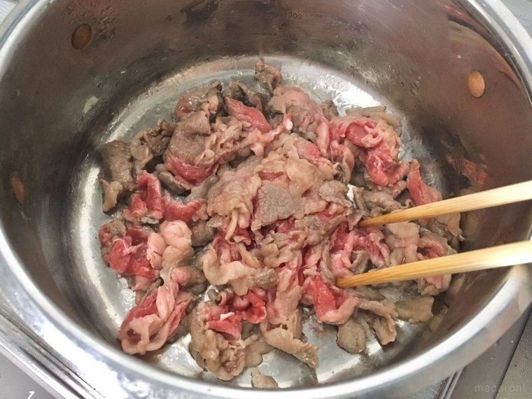 鍋で炒められている牛肉