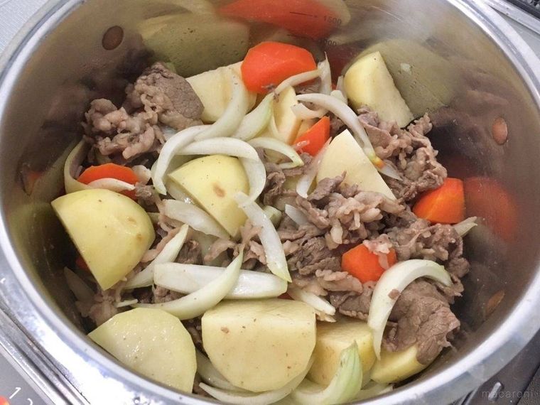 鍋で炒められている牛肉とじゃがいもとにんじんと玉ねぎ