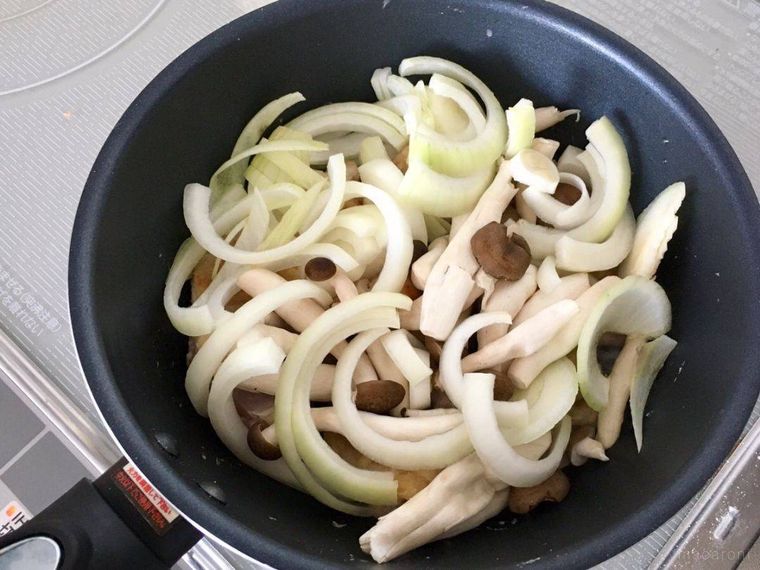 フライパンで焼かれている玉ねぎとしめじと鶏もも肉