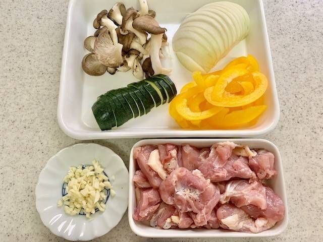 下ごしらえをした鶏もも肉や薄切りにした野菜ののった白いトレー